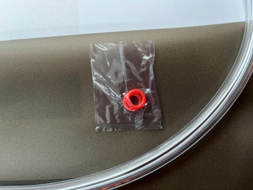 Red rubber seal ring in packaging next to clear drinking tube, related to hydration solutions for outdoor activities.
