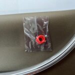Hydration bladder accessory pack containing a red sealing ring, positioned on a smooth surface, relevant for Pure Clear® hydration solutions.