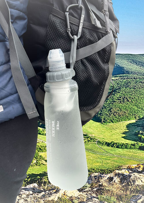 Pure Clear® 1000ml filter water bottle attached to a backpack, showcasing durable design and hydration for outdoor adventures.